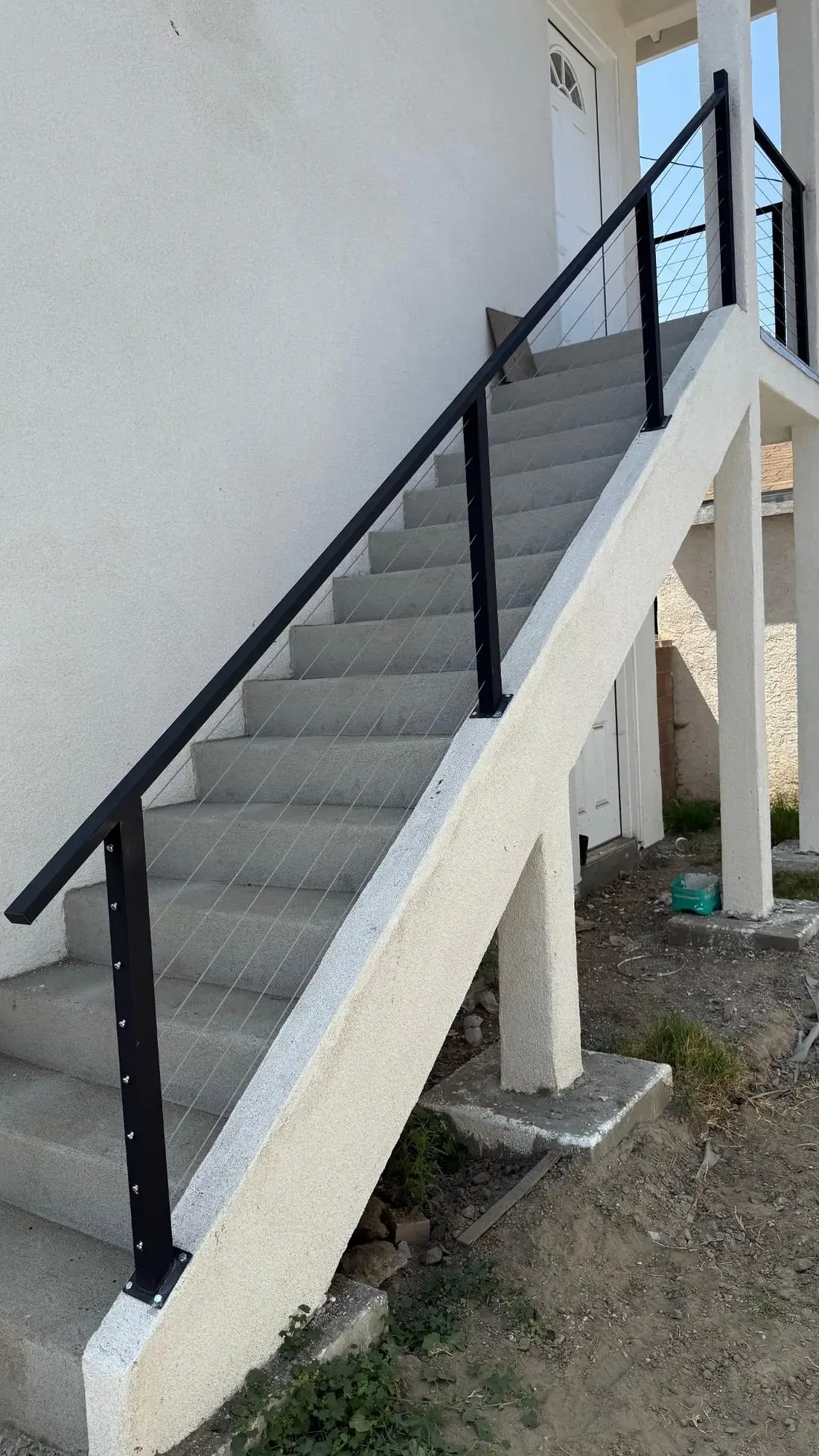 Exterior vertical metal handrail on residential stairs
